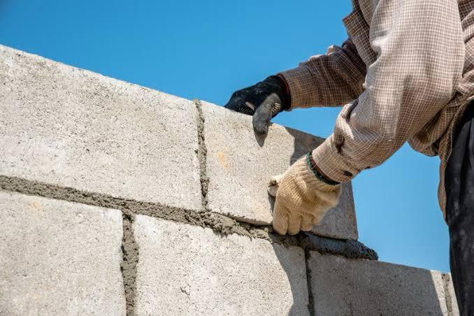 Skilled mason installing premium fly ash brick on construction site